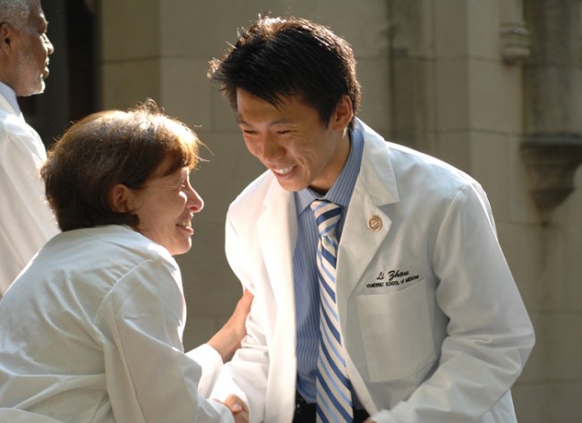 Bonnie Miller, M.D., congratulates Li Zhou after he received his coat. (photo by Anne Rayner)