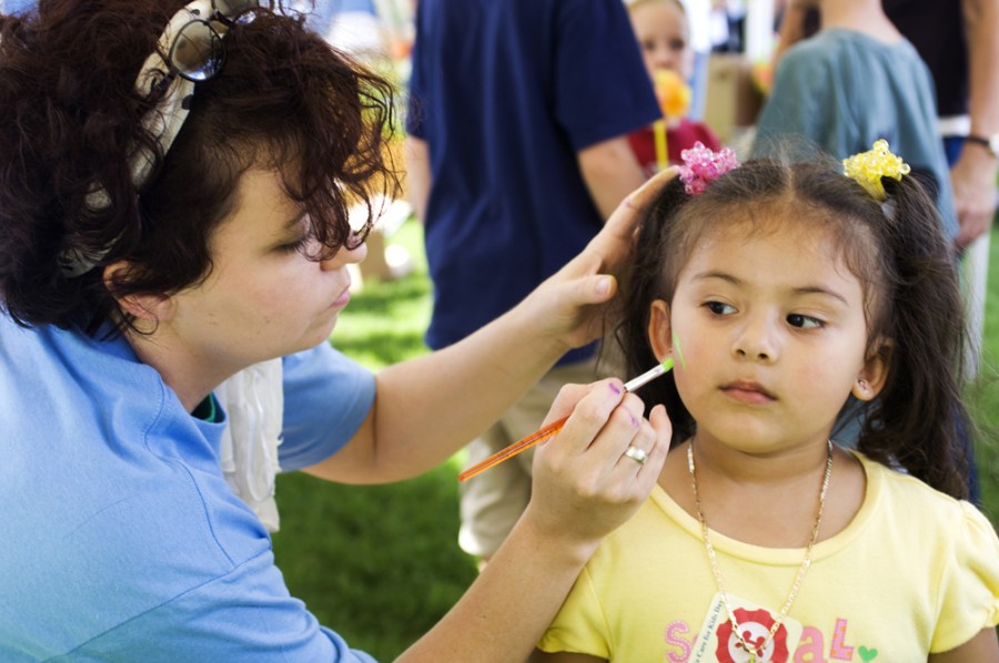 Ashley Guerra, 3, has her face painted by Daffney Hardison.