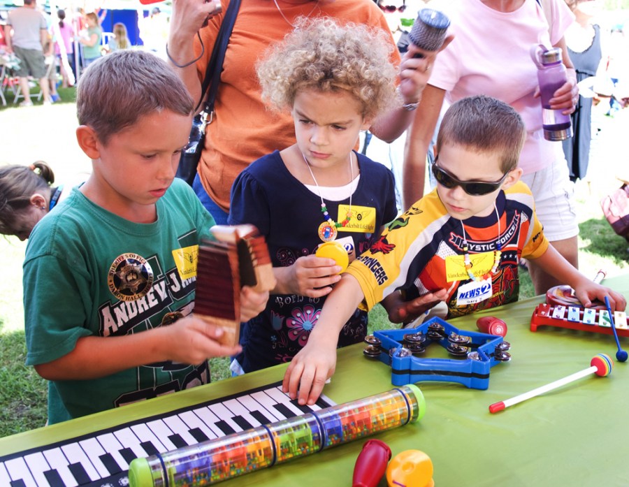 Dylan Bgorkland, 8, left, Mattie Davis, 7, and Gary Davis, 5, try out the musical instruments.