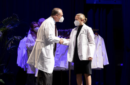 Hannah Giannini is congratulated by Jeff Balser, MD, PhD.