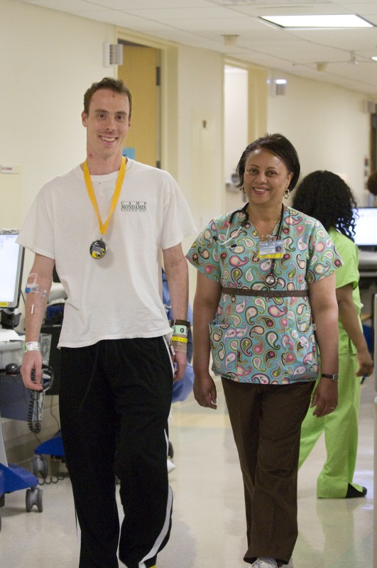 Whit Wilson, who suffered a heart attack after completing the Country Music Half Marathon, exercises in the Cardiac Unit with Sandra Welch, R.N. (photo by Mary Donaldson)