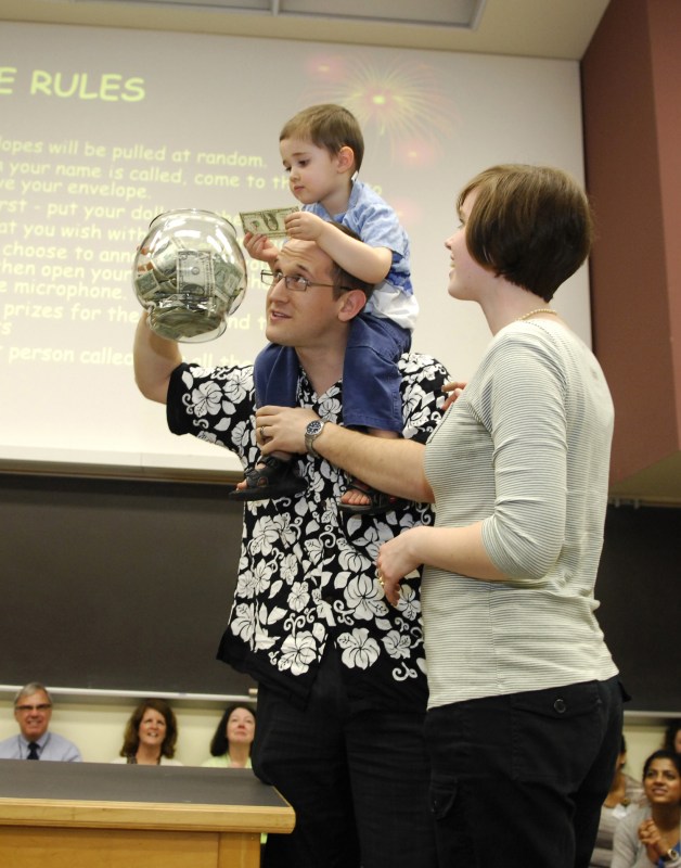 Conrad Myler gets some help stuffing the fish bowl from his son, Cohen, as his wife, Becca, looks on. (photo by Anne Rayner)