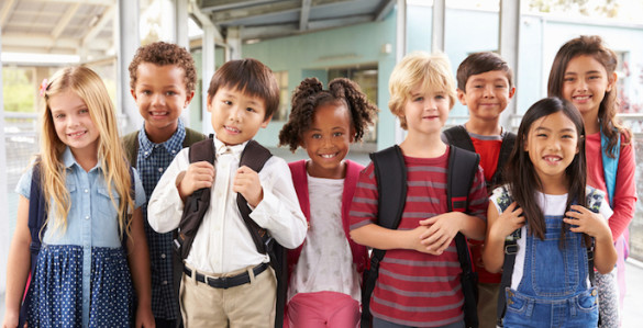 Group portrait of diverse elementary school kids in school corridor