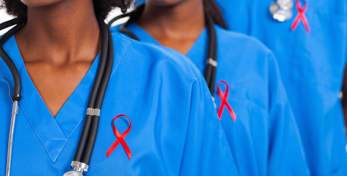 doctors wearing scrubs with red aids awareness ribbons pinned to shirts