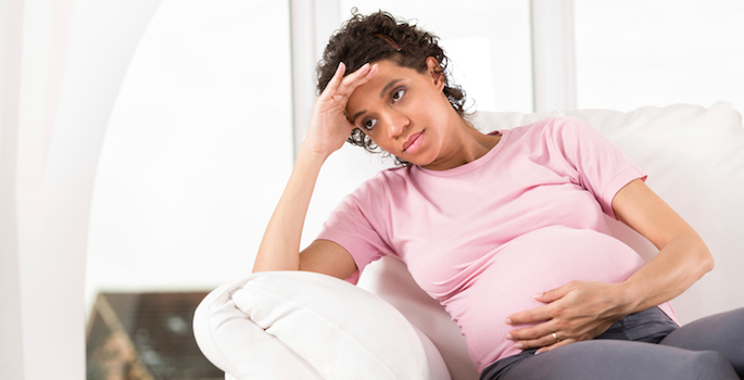 pensive pregnant african american woman at home