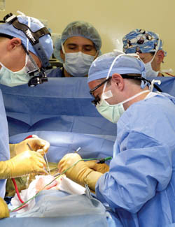 Ahmed Mahmood is surrounded by doctors during the surgery to remove a large myelomeningocele on his back due to spina bifida. Dr Paul Boone, right, performed the surgery along with Dr. Oran Aaronson, left.  (Photo by Neil Brake)