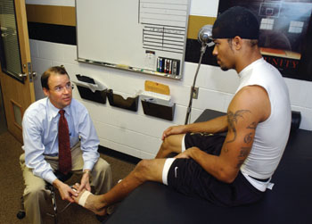 Spindler examines Commodore wide receiver Eric Davis in the training room at McGugin Center after a recent practice.
photo by Dana Johnson