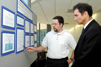 Graduate student Patrick Fueger, left, talks with symposium speaker Dr. Gerald Shulman in the poster session Wednesday. (photo by Dana Johnson)