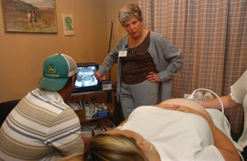 Chescheir shows patient Kim Fitzgerald and her husband Danny an image of their son during her ultrasound at a clinic visit. 
photo by Dana Johnson