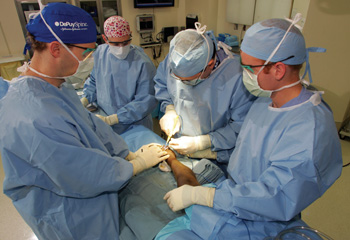 Gregory Mencio, M.D., second from right, and his team operate on Bertrang Joseph to repair his club feet.
Photo by Neil Brake