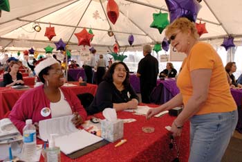 Midori Lockett, left, and Crystal Laster check in Julie Cruz so she could claim her turkey on Monday.
Photo by Dana Johnson