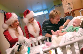 Patient Oak Cartee, 7 months, and his father, Carl, get a kick out of Erin Lindsay and Theresa Pelicata of the Rockettes during their visit last week to the Monroe Carell Jr. Children's Hospital at Vanderbilt.
Photo by Dana Johnson