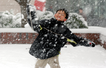 Oliver Han, 12, laughs as he throws a snowball outside the hospital. Han and several other employees’ children came to Vanderbilt after schools were closed during the snowstorm last Thursday. (photo by Dana Johnson)
