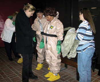 Class participants learn how to "suit up" in the specially designed hazardous materials suits. All openings have to be taped to keep out any decontamination that could injure the responder. 