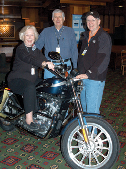 Former Board of Trust member Peggy Wood, Dr. Harold L. Moses and Dr. Raymond N. DuBois check out a Harley-Davidson that was raffled off at Country in the Rockies. Dr. C. Wright Pinson wonthe motorcycle and gave it to his brother, Lex. Photo by Alan Mayor.
 