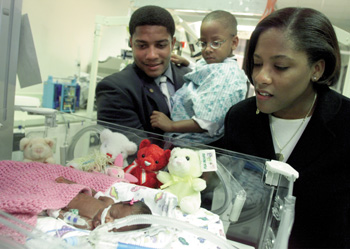Justin and his parents Kraig and Dorenda Washington stop and check on NICU patient MaKayla Dickerson while touring the unit.(photo by Dana Johnson)