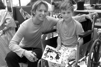 Heil poses for a picture with patient Nathan DeWitt, 9, in the Vanderbilt Children’s Hospital playroom. Sonic Flood read to the children and shared some of their music before visiting other patients in their rooms. (photo by Dana Johnson)