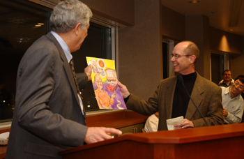 Dr. Harold Moses presents Larry Marnett with a caricature of Marnett, his sports car, the new Preston Building, a “super aspirin” and Mrs. A.B. Hancock Jr., who funds the lab Marnett directs. (photo by Anne Rayner Pollo)
