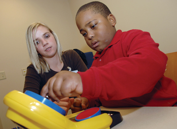 Reuben Johnson, 6, practices motor skills with occupational therapy student Stacie Campbell. (photo by Dana Johnson)
