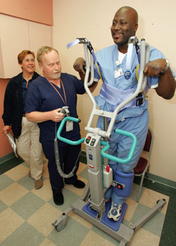 Donta Tibbs, right, tries out a component of the Smooth Moves system that helps patients stand up while Nancy Fuller and Robert Francis look on.
Photo by Neil Brake