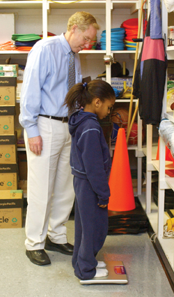 Tom Cook, Ph.D. weighs Ladundrey Brooks, a third-grade student at Stratton Elementary School.