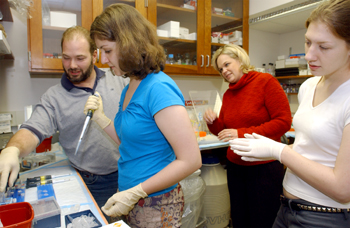 Brent Thompson, left, a fourth-year graduate student in Ron Emerson's lab, shows Virginia King, the Tennessee statewide Brain Bee winner, how to pipette during a visit to the lab this week. Her teacher Angela Butler and first runner-up Rachael Schirmer, right, look on.  All are from Immaculate Conception High School in Memphis. The Brain Bee is a 100-question Internet exam that is offered to high school students across the state as part of Brain Awareness Month.