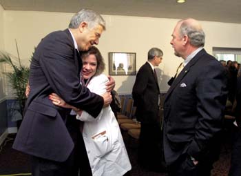 Dr. Barbara Murphy gets a hug from Dr. Hal Moses after the NCI press conference last week.  Murphy is the director of the Pain and Symptom Management program at VICC.   Dr. Harry Jacobson, vice chancellor for Health Affairs, looks on. (photo by Dana Johnson)