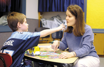 Ben Derryberry, 8, sees Jane Pramuk, a speech-language pathologist, for help communicating beyond the barriers of autism. Pramuk works at improving Ben’s verbal ability and getting past his tendency to insulate himself socially. (photo by Anne Rayner Pollo)