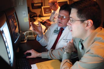 Martin Sandler, M.D., center, studies a PET scan with Daniel Scanga, M.D., a resident in the Department of Radiology and Radiological Sciences. 
photo by Dana Johnson