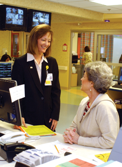 Chenger visits with Betty Ellis, a medical receptionist on the fifth floor of Children’s Hospital. Photo by Dana Johnson