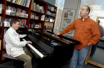 Tom Cleveland, Ph.D., rehabilitates the singing voice. "Some let the sound drive the voice," he says. Here he works with Drew Cline. (photo by Dana Johnson)