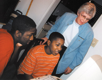 Shepherd helps Antonio Hayden, left, and Deonta Johnson set up their new computer at home.  (photo by Leigh MacMillan)