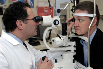 A strong clinical program is crucial to Sternberg, here examining patient David Perdue in the Ophthalmology clinic. (photo by Dana Johnson)