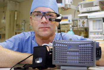 James M. Berry, M.D., professor of Anesthesiology, wears goggles that serve as the viewer for the small computer that is attached to his waist. Photo by Dana Johnson