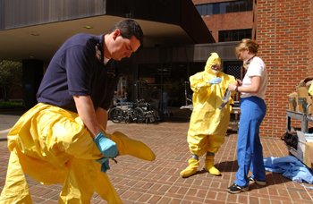 Nurses Kevin Nooner, Sherry Franks, and Erin Chaney take off their protective suits after the drill.