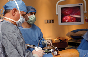 Wallace Neblett, M.D., left and surgical resident James Broome, M.D., remove a tumor from Winnter Reynolds’ adrenal gland. (photo by Susan Urmy)