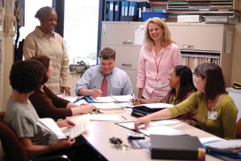 Psychiatric Hospital at Vanderbilt Magnet Champion Laura Zavisa, R.N., standing, right, talks with members of the Children’s Unit, from left: Ro Wallace, R.N., child unit coordinator; Emma Finan, R.N., utilization management; Loretta Smith, medical receptionist; John Jackson, clinical director; Kimberly Davis, coding specialist; and Cindy Jackson, child/adolescent social worker, about the upcoming Magnet visit.                        
Photo by Dana Johnson