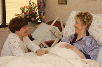 Barbara Brennan, right, talks with her daughter Lynne Bevins about the twins' progress while resting in her hospital room. Brennan carried and delivered the twins for her daughter. Photo by Dana Johnson.