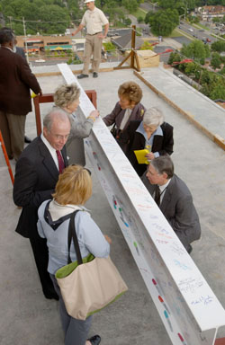 Monroe Carell Jr. talks with guests as Martha Ingram, Dr. Pat Temple, and Dr. Steven Gabbe add their autographs to the ceremonial beam. (photo by Anne Rayner Pollo)