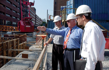 Fred DeWeese, center, Jeff Kaplan, right, and a contracting supervisor examine the progress of the construction project taking shape behind Langford Auditorium.
photo by Dana Johnson