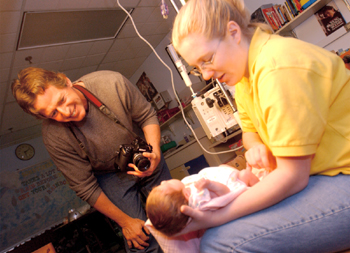 Tim Campbell, left, gets a closer look at 2-week-old Isabella Alexander, held by her mother Hilary Washer. Campbell volunteers to take patients’ portraits at no cost once a month at Vanderbilt Children's Hospital.