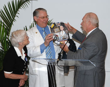 Harry Jacobson, M.D., right, presented Gabbe with his own bobblehead doll as Gabbe’s wife, Patricia Temple, M.D., looks on. (photo by Neil Brake)