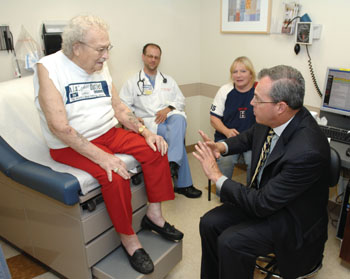 Byrne talks with patient Dewell Reynolds during a clinic visit, as Sean Smithey, N.P., and Reynolds’ daughter, Dixie Manning, look on. (photo by Neil Brake)