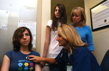 Michelle Schierling, M.D., evaluates Ashley Brinsko during triage in Vanderbilt’s Emergency Department as Ashley’s sister, Alexis, and mother, Vicki, look on.
(photo by Susan Urmy)
