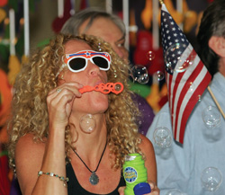 Tobi Fishel, Ph.D., an assistant professor of Psychiatry, shows off her bubble-blowing skills and patriotic sunglasses. (photo by Neil Brake)
