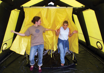 Vanderbilt School of Nursing students Mia Pelt, left, and Summer Keasler walk through the Nashville Fire Department’s decontamination shower and tent as if they had been exposed to a dangerous chemical or biological agent on the scene of an emergency situation. The simulation was part of a bioterrorism training program for first-year nursing students. 
