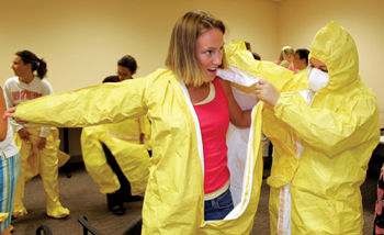 First-year Vanderbilt nursing students trained to work during an emergency situation involving deadly chemicals or biological agents while wearing restrictive personal protective equipment. Nursing student Shawna Jensen, left, gets help putting on her safety suit from Abigail Morgan. 