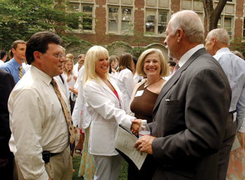 Harry R. Jacobson, M.D., vice chancellor for Health Affairs, right, congratulates Kim Sandler, after she received her white coat, and her parents, Martin Sandler, M.D., and Glynnis Sachs, M.D.
photo by Anne Rayner