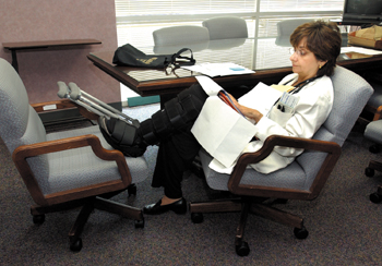 German props her foot up while reviewing charts in a clinic conference room before seeing patients. She suffered a lisfranc fracture this year after a fall.