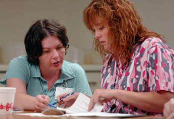 Nicole Hutcherson, left, and Leslie Smith work on their surveys at the Psychiatric Hospital nursing staff council meeting last week. (photo by Dana Johnson)